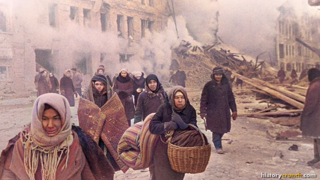 Soviet civilians leaving destroyed houses after a German bombardment during the Siege of Leningrad in December of 1942. (Colorized by historycrunch.com)