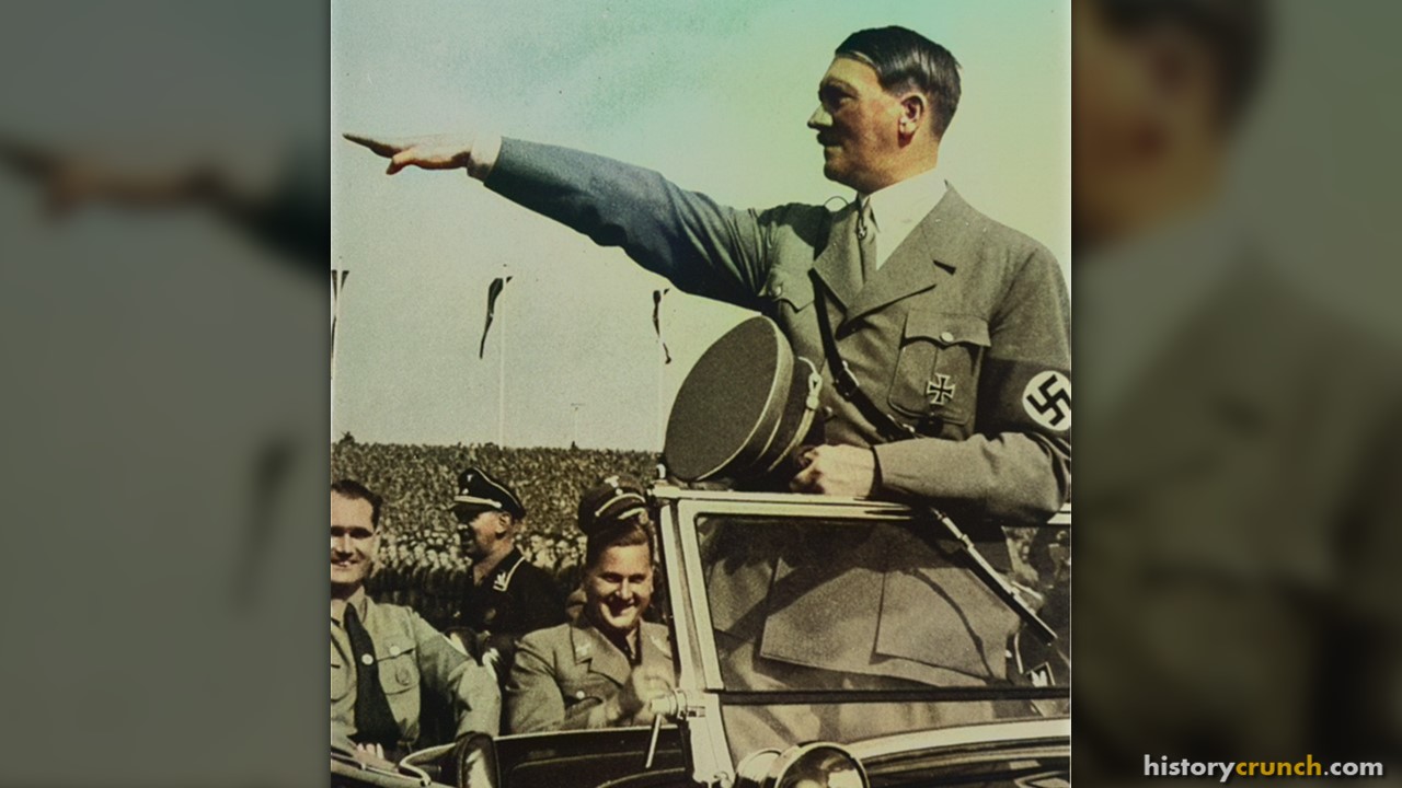 Adolf Hitler salutes a mass rally of Nazi supporters in 1930s Germany. Hitler is an example of totalitarianism in the 20th century. (Colorized by historycrunch.com)